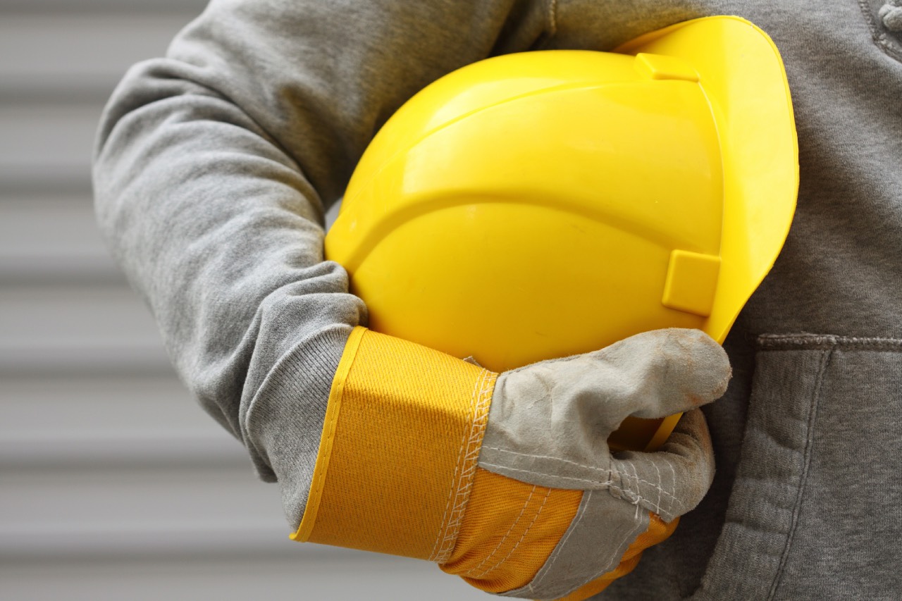 Man carrying his yellow safety hat - Aluman S.A.